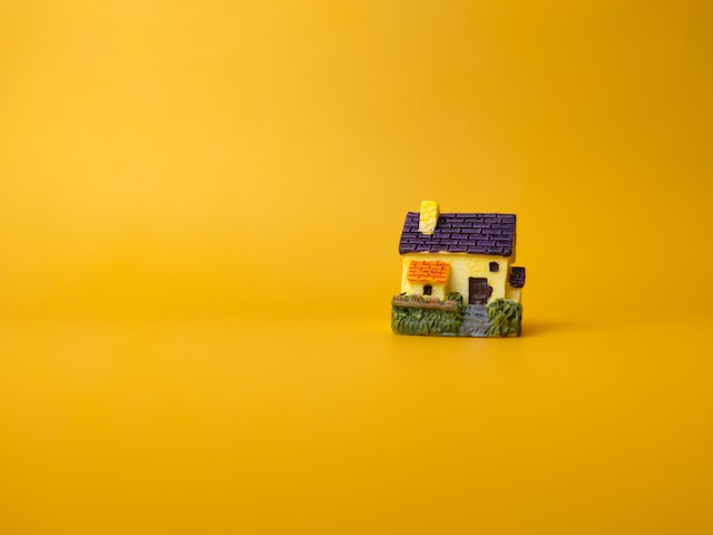 model of a house in yellow background